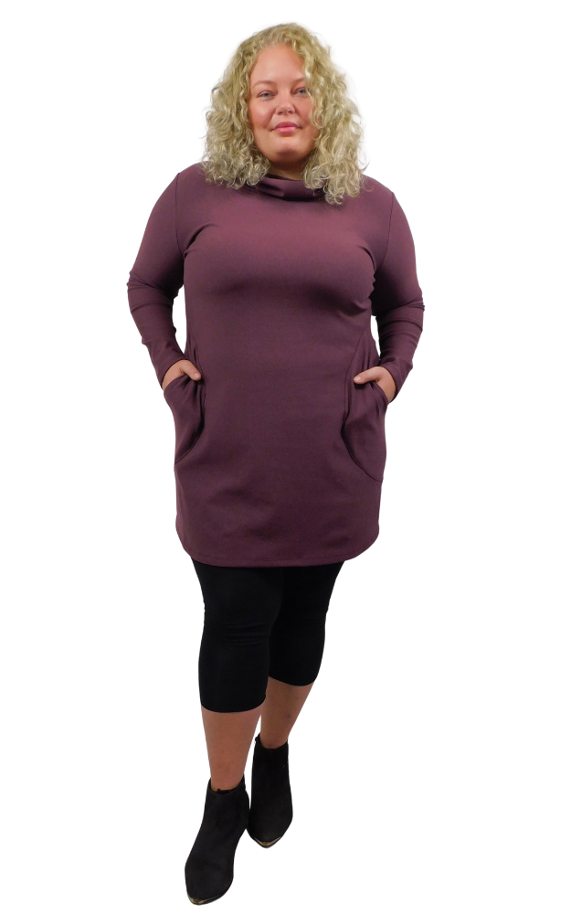 Woman wearing a wine coloured dress with pockets on a white background