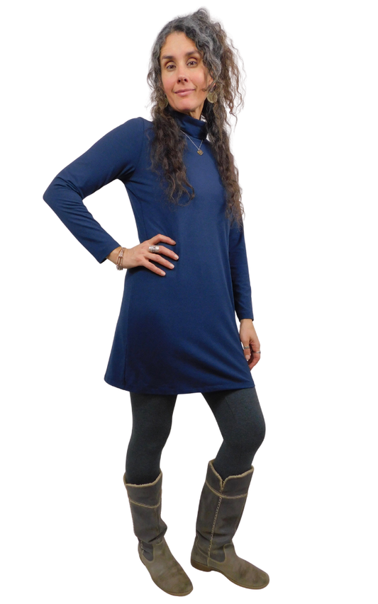 Woman wearing a blue dress and grey boots on a white background