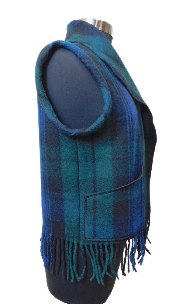 Blue, green and black tartan vest with fringes on a mannequin against a white background