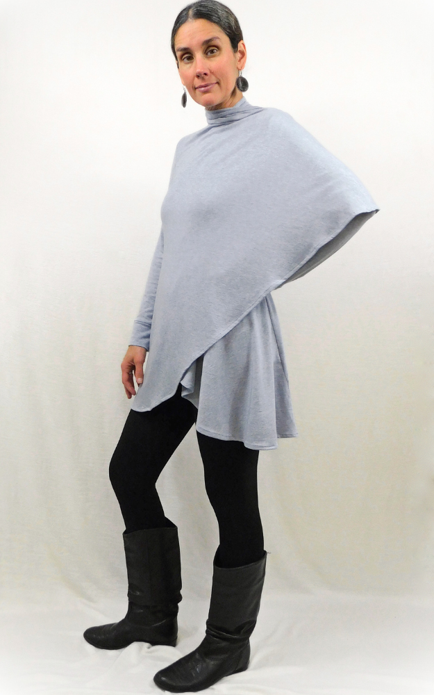Woman standing sideways with one arm on hip wearing cardigan that wraps around shoulder and arm