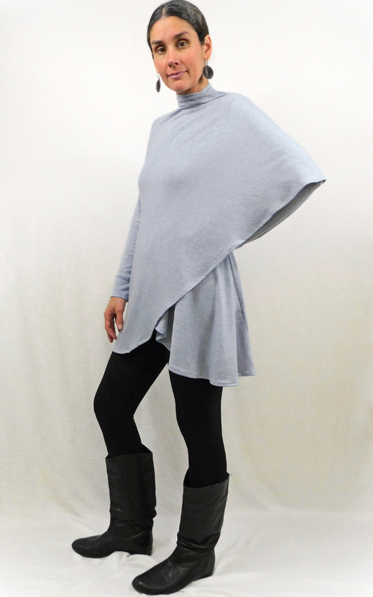 Woman standing sideways with one arm on hip wearing cardigan that wraps around shoulder and arm