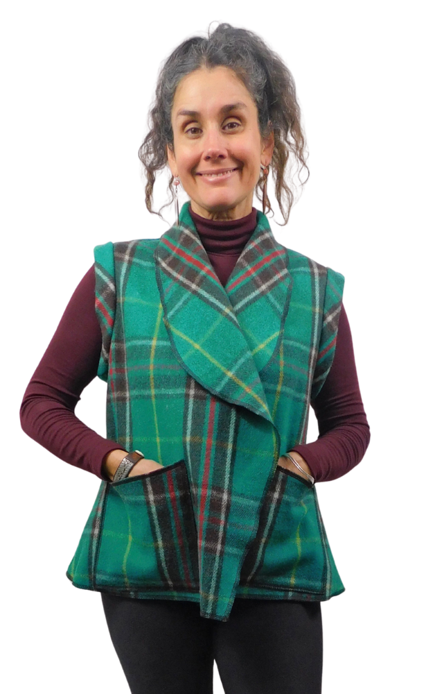 Woman wearing a green and black tartan plaid vest over a wine sweater and black pants
