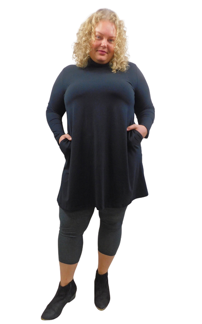 A woman modeling a long-sleeve, high-neck turtleneck tunic dress in Black  styled with charcoal leggings