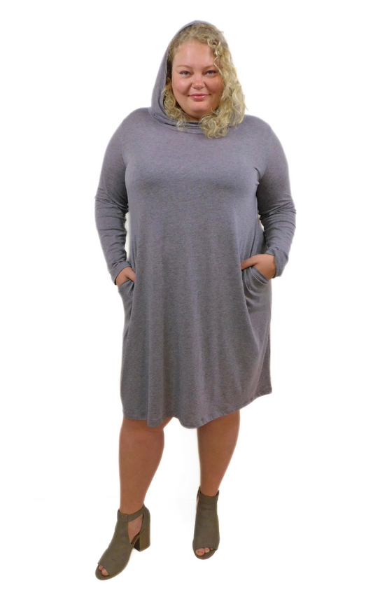 Plus size woman wearing long sleeve dress with hands in pockets and hood up