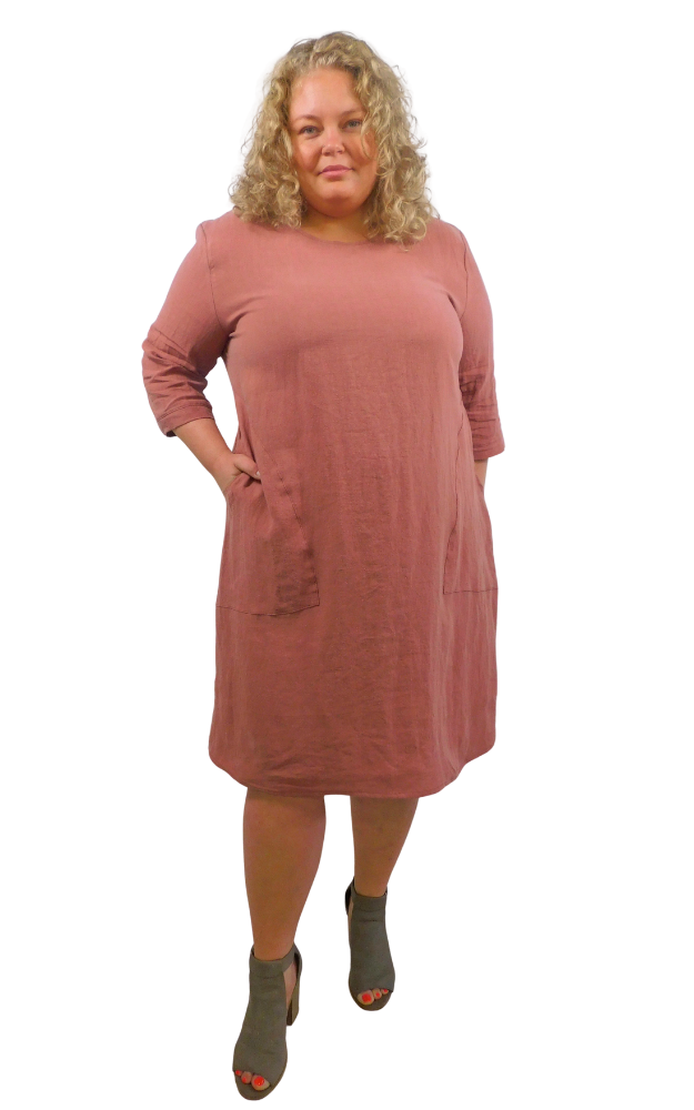 Woman wearing a rose coloured dress against a white background