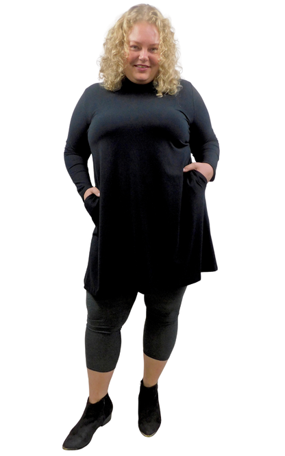 A woman modeling a long-sleeve, high-neck turtleneck tunic dress in Black  styled with charcoal leggings