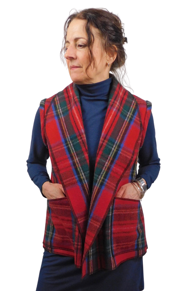 Woman wearing a red tartan vest over a blue outfit on a white background