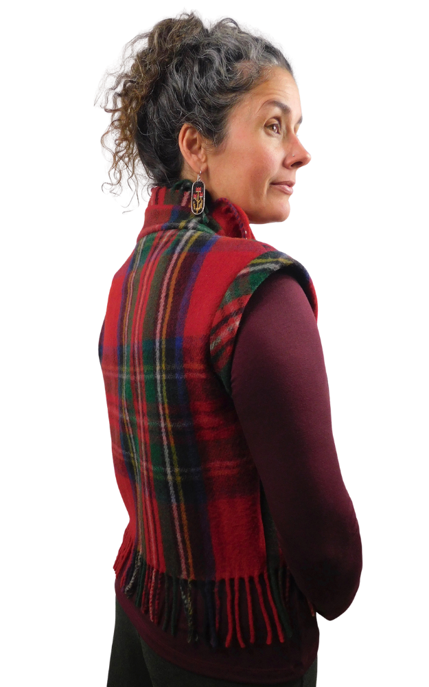 A woman shown from the back and side profile wearing a red tartan plaid fringed vest over a burgundy long-sleeve top, against a plain white background.