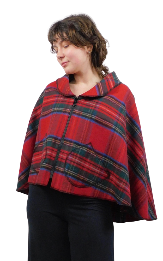 Person wearing a red plaid cape on a white background