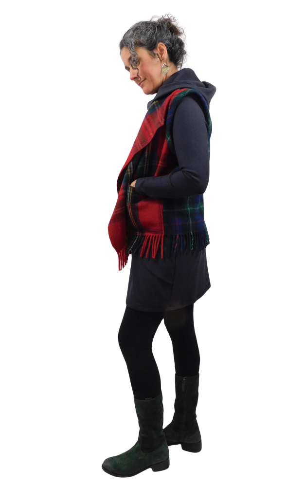 Person wearing a tartan vest over a dark outfit on a white background