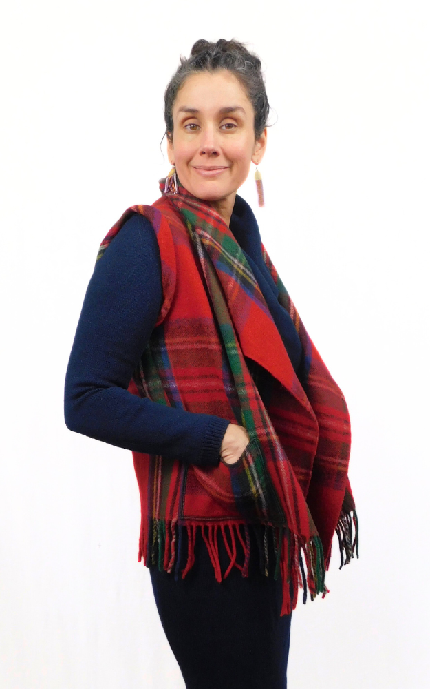 Side View of woman wearing a red, green and black tartan vest with fringes