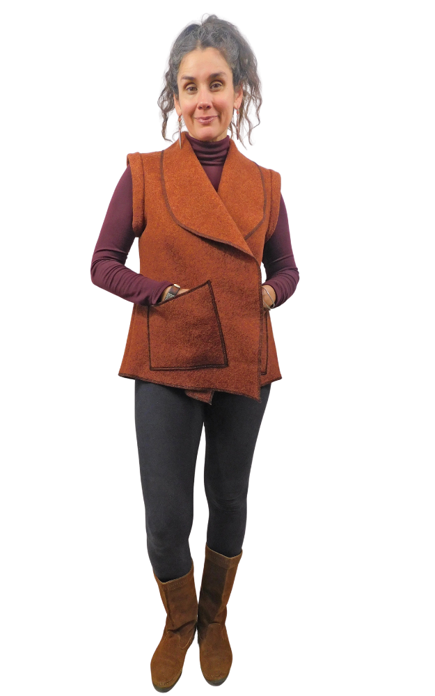 Woman wearing a rust coloured vest with one hand in patch pocket