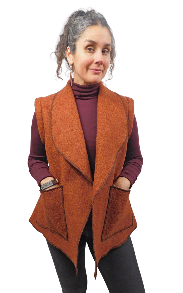 Woman wearing a rust colour boiled wool vest with hands in patch pockets