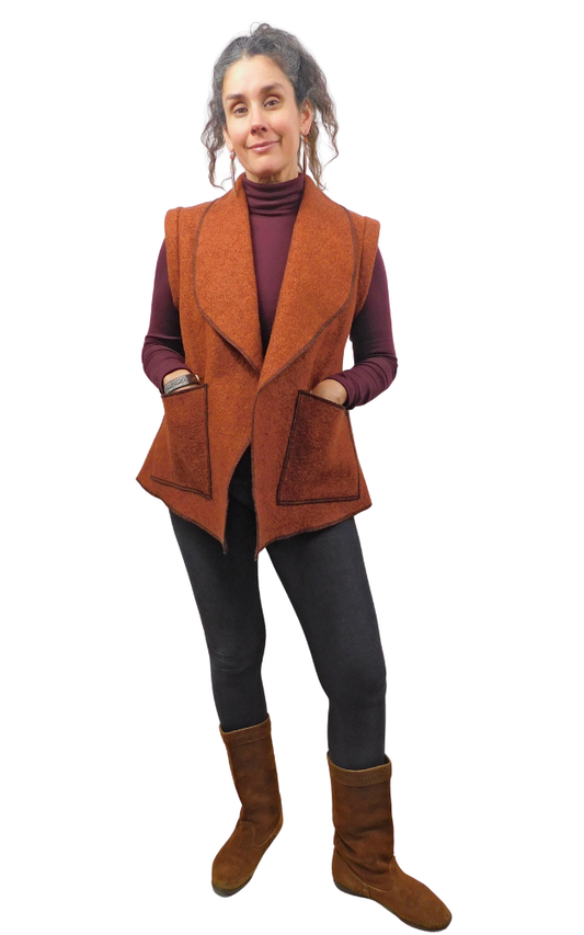 Woman wearing a rust colour vest with hands in pocket