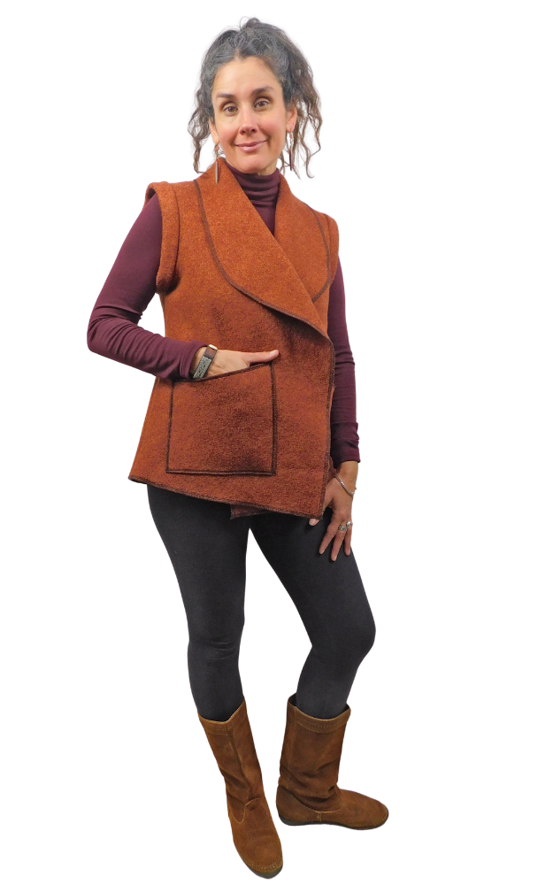 Woman wearing a rust colour vest with one hand in pocket