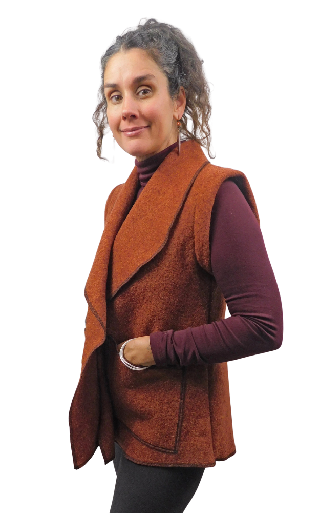 Woman wearing a rust colour boiled wool vest with hands in patch pockets
