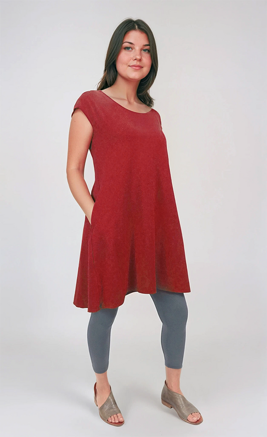 Woman wearing a red dress and gray leggings on a white background