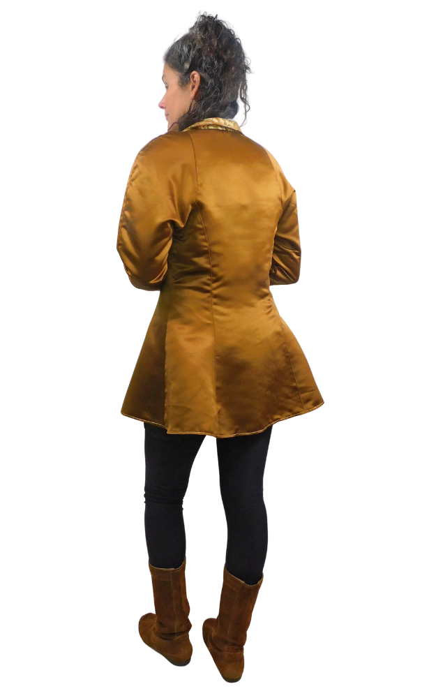 Back view of woman wearing a bronze long vest jacket over a black outfit on a white background