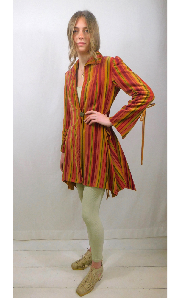 Woman wearing a colorful striped coat with a white background