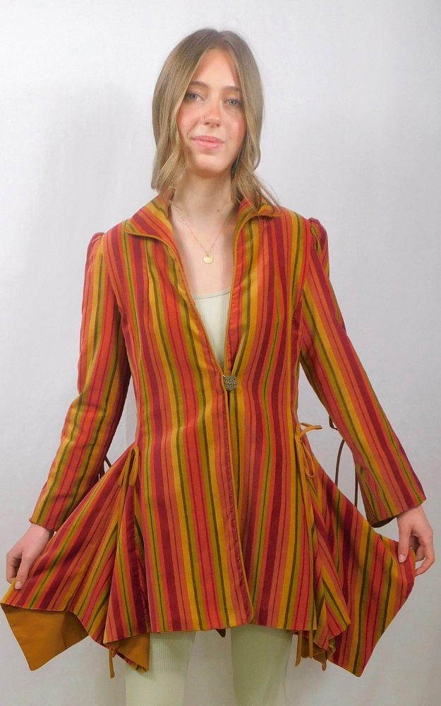 Woman wearing a colorful striped coat with a white background