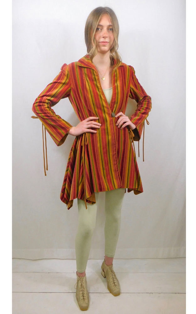 Woman wearing a colorful striped coat with a white background