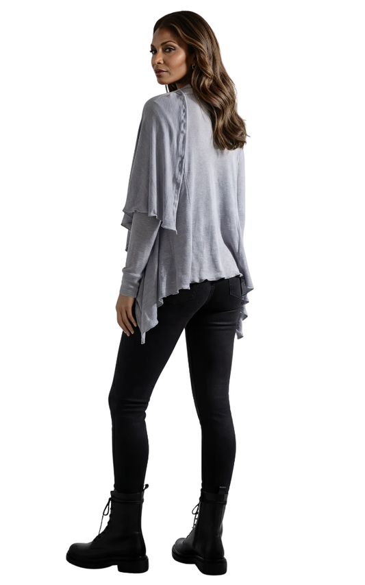 Woman wearing a light gray wrap cardigan over a black outfit on a white background