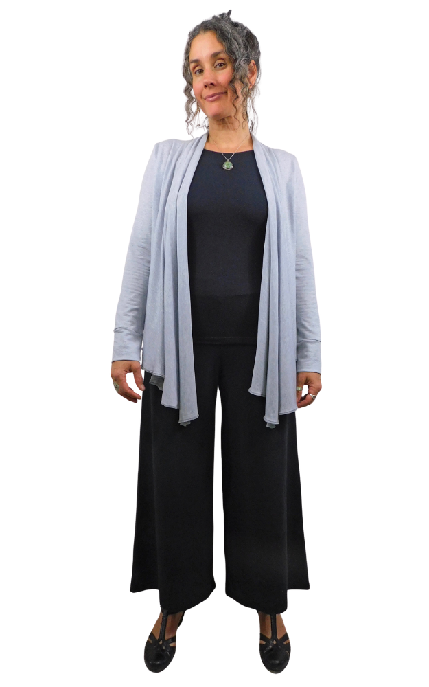 Woman wearing a light gray cardigan over a black outfit on a white background