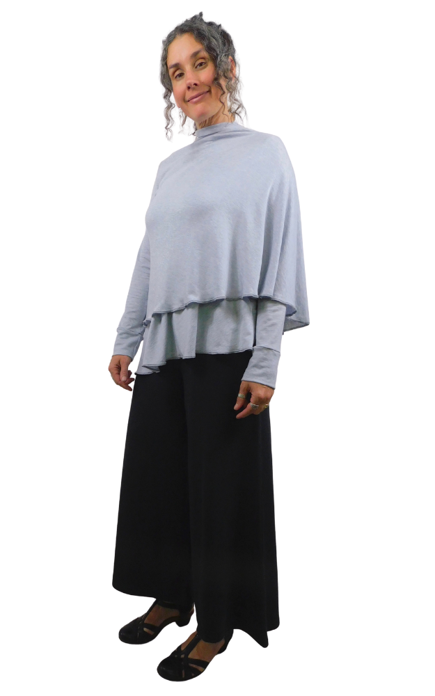 Woman wearing a light gray wrap top and black pants on a white background