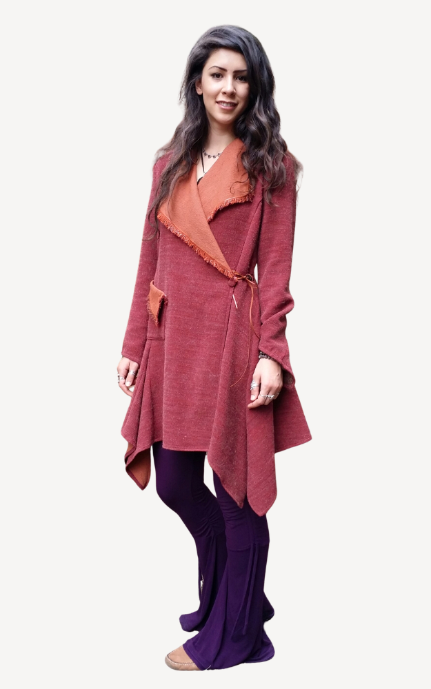 Woman wearing a long, burgundy cardigan over a rust-colored top on a white background