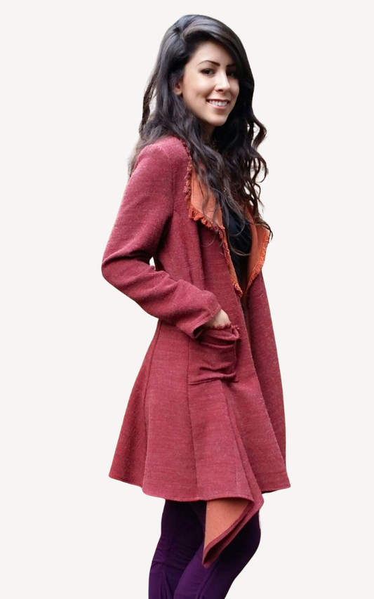 Woman wearing a long, burgundy coat on a white background