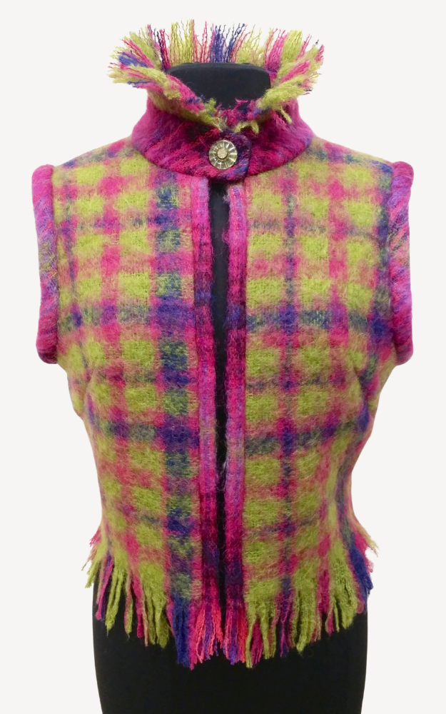 Colorful plaid vest with fringe on a mannequin against a white background