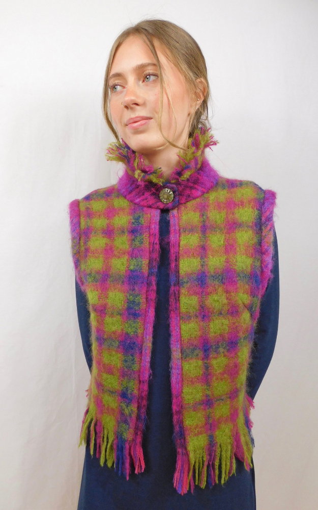 Woman wearing a colorful plaid vest with a white background