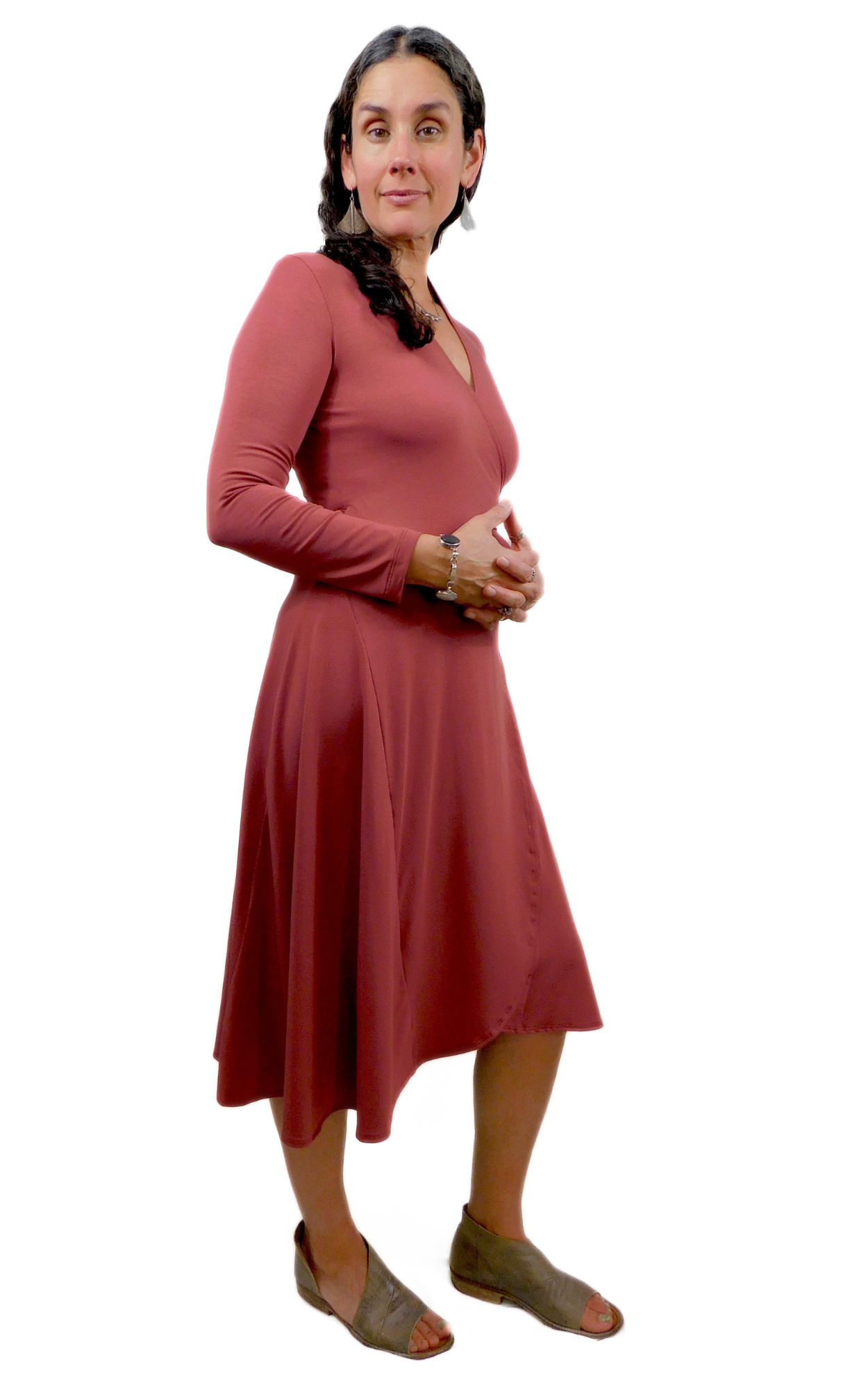 Woman standing sideways wearing wine coloured wrap dress long sleeves tie belt below knee hem