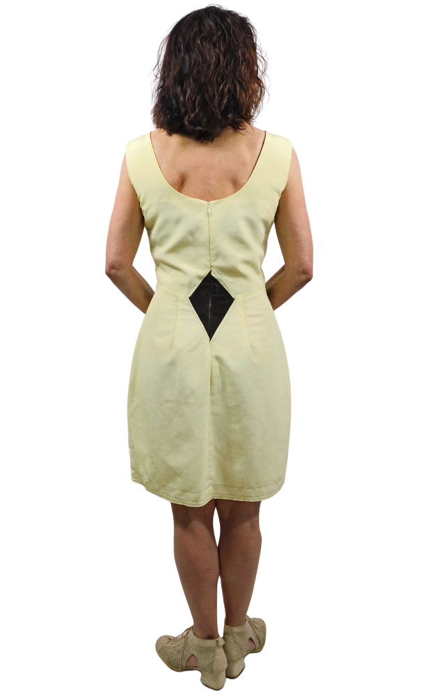 Back view of a woman wearing a yellow dress with a  brown diamond design on a white background