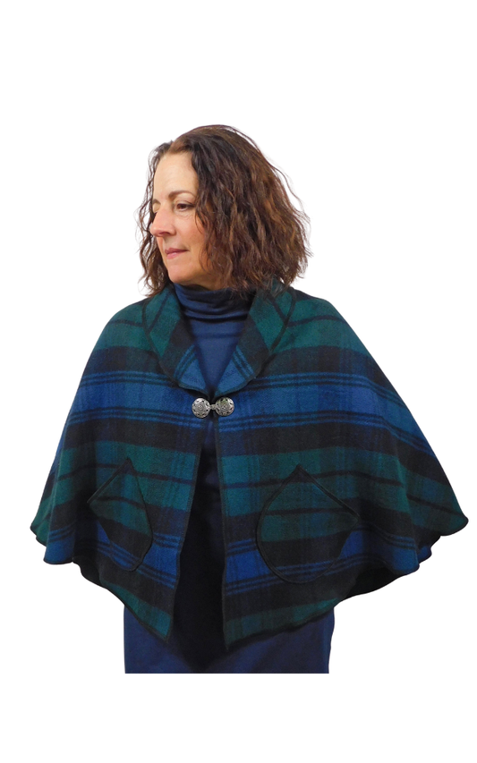 Woman wearing a blue and green plaid tartan cape on a white background